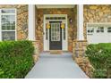 Inviting front porch with stone accents, perfect for welcoming guests to this beautiful home at 5021 Meadow Woods Dr, Lowell, NC 28098
