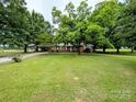 Well-manicured lawn surrounds this brick home with mature trees and a long driveway at 5628 White Store Rd, Wingate, NC 28174