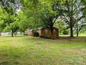Brick home with mature trees, green grass, and landscape design at 5628 White Store Rd, Wingate, NC 28174