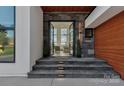 Inviting home entryway with stone steps, ambient lighting, and glass double doors at 5930 Midsomer Rd, Charlotte, NC 28214