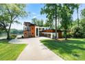 Contemporary home showcasing a sleek design, a spacious driveway, and beautifully manicured lawn at 5930 Midsomer Rd, Charlotte, NC 28214