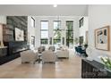 Bright, spacious living area with large windows, a stone fireplace, and an open floor plan offering stunning water views at 5930 Midsomer Rd, Charlotte, NC 28214