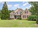 Classic brick home showcasing a manicured front lawn, symmetrical design, and a welcoming entrance with detailed architectural features at 6057 Erie View Ct, Denver, NC 28037