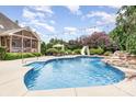 Backyard inground pool featuring a waterfall feature, slide, lights, and patio furniture at 6057 Erie View Ct, Denver, NC 28037