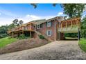 Brick home with wood deck, ground-level covered parking and a winding driveway at 6294 Southlake Dr, Hickory, NC 28601