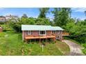 Charming brick home featuring an expansive wooden deck and lush green lawn at 6294 Southlake Dr, Hickory, NC 28601