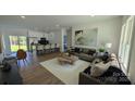 Open-concept living area featuring hardwood floors, stylish decor, and seamless flow to the kitchen island at 6386 Cathedral Dr, Granite Falls, NC 28601