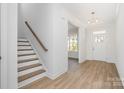 Welcoming entryway with wood-look floors, white trim, a staircase, and a paneled front door at 722 Lithia Inn Rd, Lincolnton, NC 28092