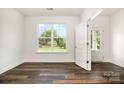 A bright, minimalist bedroom with hardwood floors, a large window and white trim at 726 Lithia Inn Rd, Lincolnton, NC 28092