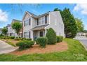 Shot of gray two-story home featuring manicured landscaping at 7671 Bluff Point Ln, Denver, NC 28037