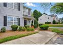 View of gray two-story home featuring well-maintained landscaping at 7671 Bluff Point Ln, Denver, NC 28037