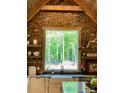 Rustic kitchen sink view with brick accent wall and view of outside wooded area at 770 Highway 274 Rd, Clover, SC 29710