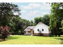 Charming exterior view of the home nestled amidst lush trees, offering privacy and a serene setting at 8340 Brief Rd, Mint Hill, NC 28227