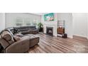Cozy living room with a fireplace, comfortable seating, and lots of natural light from the windows at 9525 Festival Way, Charlotte, NC 28215