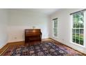 Bright living room with hardwood floors, oriental rug, and large windows overlooking the yard at 9901 Pallisers Ter, Charlotte, NC 28210
