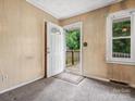 Cozy foyer with patterned carpet and an open doorway leading to the exterior deck at 1008 Midway Dr, Gastonia, NC 28054