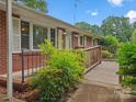 View of brick facade with wooden ramp leading to front door, complemented by well-maintained landscaping at 1008 Midway Dr, Gastonia, NC 28054