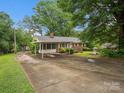 Wide exterior view of home with covered parking, driveway and spacious front yard at 1008 Midway Dr, Gastonia, NC 28054