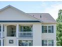 Close view of a building featuring white siding, a balcony, and windows with dark blue shutters at 1023 Triece Ln, Charlotte, NC 28215
