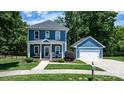 Charming two-story blue home with a detached garage, lush landscaping and well-manicured lawn at 1067 33Rd Avenue Ne Loop, Hickory, NC 28601