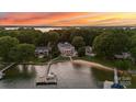 Aerial view of a waterfront estate with a dock, sandy beach, and lush landscaping at 123 Sailview Rd, Mooresville, NC 28117
