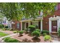 View of townhouses with brick and siding, complemented by well-maintained landscaping and inviting front entrances at 12350 Swan Wings Pl, Huntersville, NC 28078