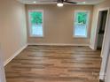 Bright bedroom with two windows, ceiling fan, and wood-look flooring at 136 Ridge Run Dr, Statesville, NC 28625