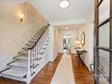 Bright foyer features hardwood floors, a staircase, and a view into the living spaces at 2919 Wickersham Rd, Charlotte, NC 28211