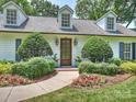 Charming home exterior with manicured landscaping, dormer windows, and a quaint entryway at 2919 Wickersham Rd, Charlotte, NC 28211