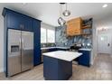 Stylish kitchen with blue cabinets, stainless steel appliances, and a modern backsplash at 304 Cabarrus W Ave, Concord, NC 28025