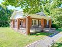 Classic brick home with a wraparound porch, offering outdoor living space and curb appeal at 435 W Whitley St, Norwood, NC 28128