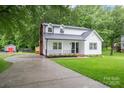 Lovely two-story home boasts a long driveway and a detached garage with a red door, surrounded by mature trees at 4633 Old Mill Rd, Gastonia, NC 28056