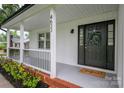 Close-up of the welcoming front porch area showcases the house number, black front door, and manicured landscaping at 4633 Old Mill Rd, Gastonia, NC 28056