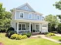 Beautiful two-story home with a welcoming front porch, lush landscaping, and a well-maintained lawn at 5424 Morris Hunt Dr, Fort Mill, SC 29708