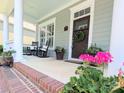 Relaxing front porch with rocking chairs, decorative plants, and a welcoming entryway at 5424 Morris Hunt Dr, Fort Mill, SC 29708