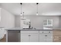 Bright kitchen island with a stainless steel dishwasher and contemporary pendant lighting, perfect for casual dining and entertaining at 6712 W Sugar Creek Rd, Charlotte, NC 28269