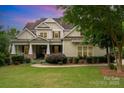 Charming traditional home with covered front porch, manicured lawn, and beautiful landscaping at 6873 Pine Moss Ln, Clover, SC 29710