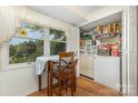 Kitchen area with small dining table, window, and walk-in pantry with shelving at 7304 Pebblestone Dr, Charlotte, NC 28212