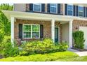 Inviting front porch with brick facade and cozy seating area for relaxing outdoors at 7930 Kelburn Ln, Charlotte, NC 28273