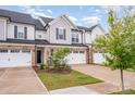 Attractive townhome showcasing brick details, a single-car garage, and lush green lawn at 9009 Odell Corners Nw Blvd, Concord, NC 28027
