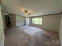 Bright living room featuring a large window and cozy carpet, ready for personal touches at 9044 Forington Ln, Gastonia, NC 28056