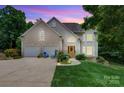 Inviting exterior with a two-car garage and a well-manicured lawn and attractive architectural elements at dusk at 133 37Th Avenue Nw Pl, Hickory, NC 28601