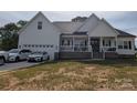 Beautiful white farmhouse with an attached garage and manicured lawn, great curb appeal at 133 Harbourtown Dr, Kings Mountain, NC 28086