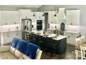 Spacious kitchen featuring white cabinets, stainless steel appliances, and a large island with seating at 133 Harbourtown Dr, Kings Mountain, NC 28086