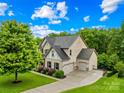 Beautiful home with lush landscaping, a three-car garage, and a long driveway surrounded by mature trees at 2289 Pine Valley Dr, Denver, NC 28037