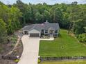 Expansive aerial view of a beautiful home featuring a long driveway, manicured lawn, and surrounded by lush trees at 2577 Bonnybrook Cir, Rock Hill, SC 29732