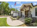 Inviting front porch with stone pillars, wood beams, black railings, and a beautifully landscaped walkway at 2577 Bonnybrook Cir, Rock Hill, SC 29732