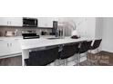 Modern kitchen island with barstool seating, stainless steel appliances, and white cabinetry at 2617 Goose Fair Rd, Maiden, NC 28650