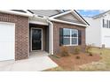 Inviting front entrance with a black door, brick accents, and manicured landscaping at 2650 Goose Fair Rd, Maiden, NC 28650