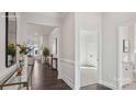 Bright hallway with hardwood floors, wainscoting, and an open view to the living room at 3128 Spring Iris Dr, Denver, NC 28037